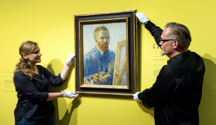 Staff at the Van Gogh Museum in Amsterdam hang a self-portrait of the artist