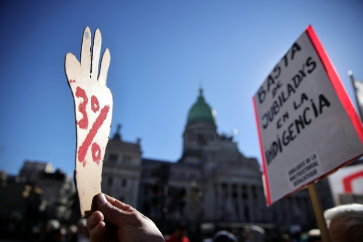 A protester holds a sign reading "3%" referring to an audio leak that allegedly links Karina Milei, sister of Argentina's president, to claims she pocketed 3% pharmaceutical sales to the country's disability agency