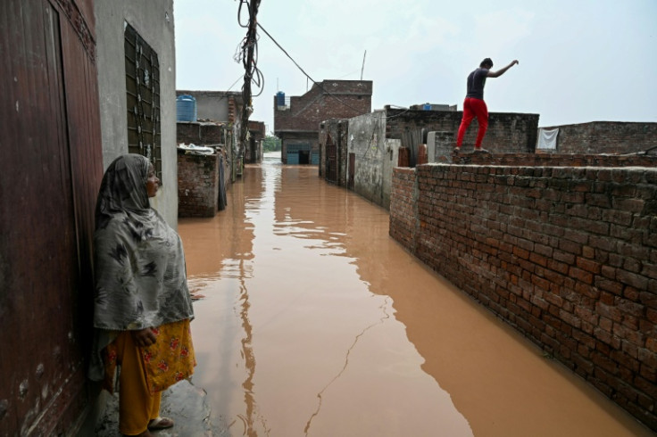 A woman stands near her submerged home, after floodwaters entered from the overflowing Ravi river in Shahdara, Lahore on August 29, 2025. Water has gushed into the eastern province, Pakistan's breadbasket and home to about half of its 255 million people,