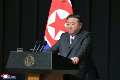 This picture released by North Korea's official Korean Central News Agency (KCNA) on August 30, 2025 shows Kim Jong Un handing over a portrait wrapped in a flag to the family of a soldier