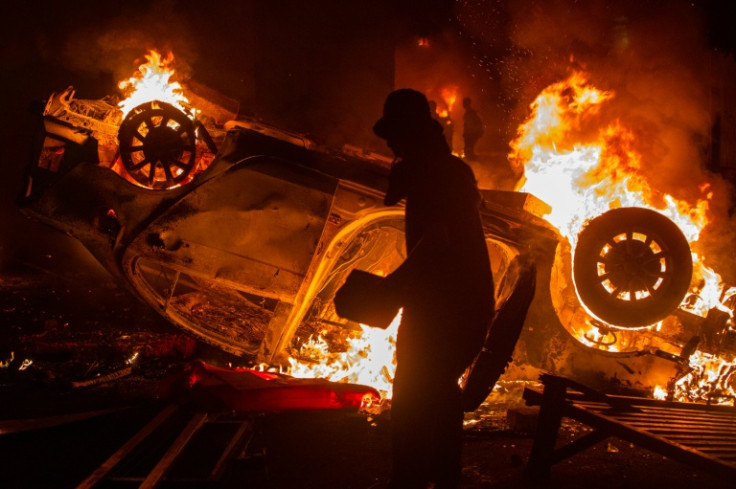 A car is set on fire during a protest in Yogyakarta following the death of a motorcycle taxi driver who was run over by an armoured Brimob (Mobile Brigade Corps) vehicle the night before