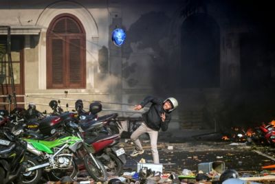 A demonstrator throws a helmet during a protest against the Mobile Brigade Corps or 'Brimob', after the death of a motorbike taxi driver the previous night