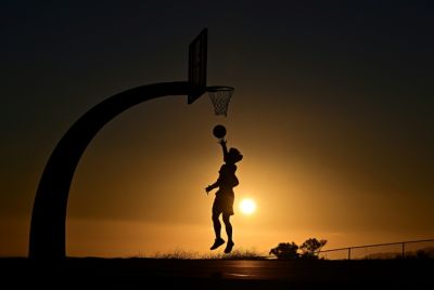 A boy shoots hoops at sunset on August 19, 2025 in San Pedro, California amid a brutal heat wave