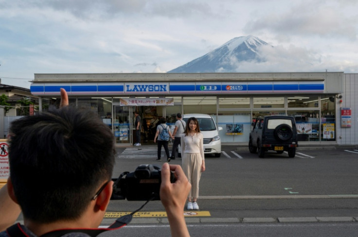 Last year authorities erected a barrier in front of a convenience store to stop tourists from blocking roads while taking pictures of Mount Fuji in the background