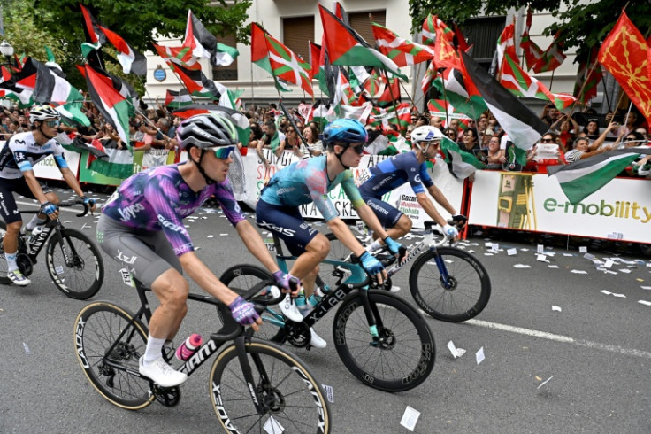 Cyclists compete as pro-Palestinian protesters demonstrate during the 11th stage of the Vuelta a Espana on September 3, 2025