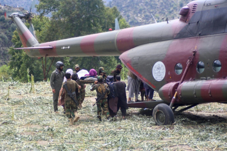 Taliban personnel carry an injured Afghan towards a military helicopter after earthquakes at Mazar Dara village in Nurgal district, Kunar province, in Eastern Afghanistan, on September 2, 2025. The earthquake killed more than 1,400 people and injured over