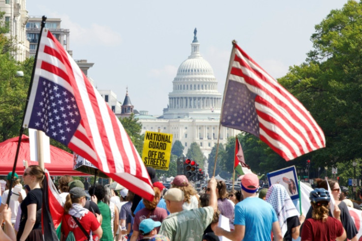 Demonstrators hold inverted US flags near the US Capitol during the "We Are All DC" national march calling for an end to the deployment of National Guard troops in Washington, DC
