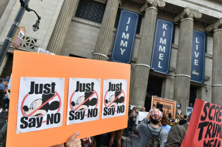 Demonstrators hold signs as they rally to protest the cancelation of the "Jimmy Kimmel Live!" show outside the El Capitan Entertainment Centre on Hollywood Boulevard, from where the show is broadcast in Hollywood, California