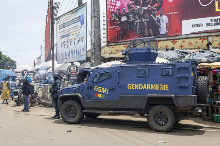 A gendarme stands guard next to an armoured vehicle in Conakry ahead of Guinea's constitutional referendum
