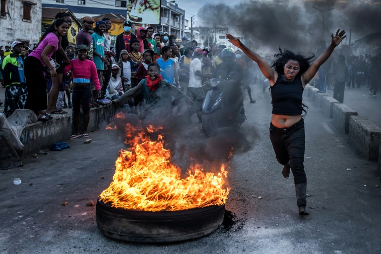 https://d.ibtimes.com/en/full/4627559/protester-runs-past-burning-tire-used-barricade-during-clashes-madagascar-security-forces.jpg