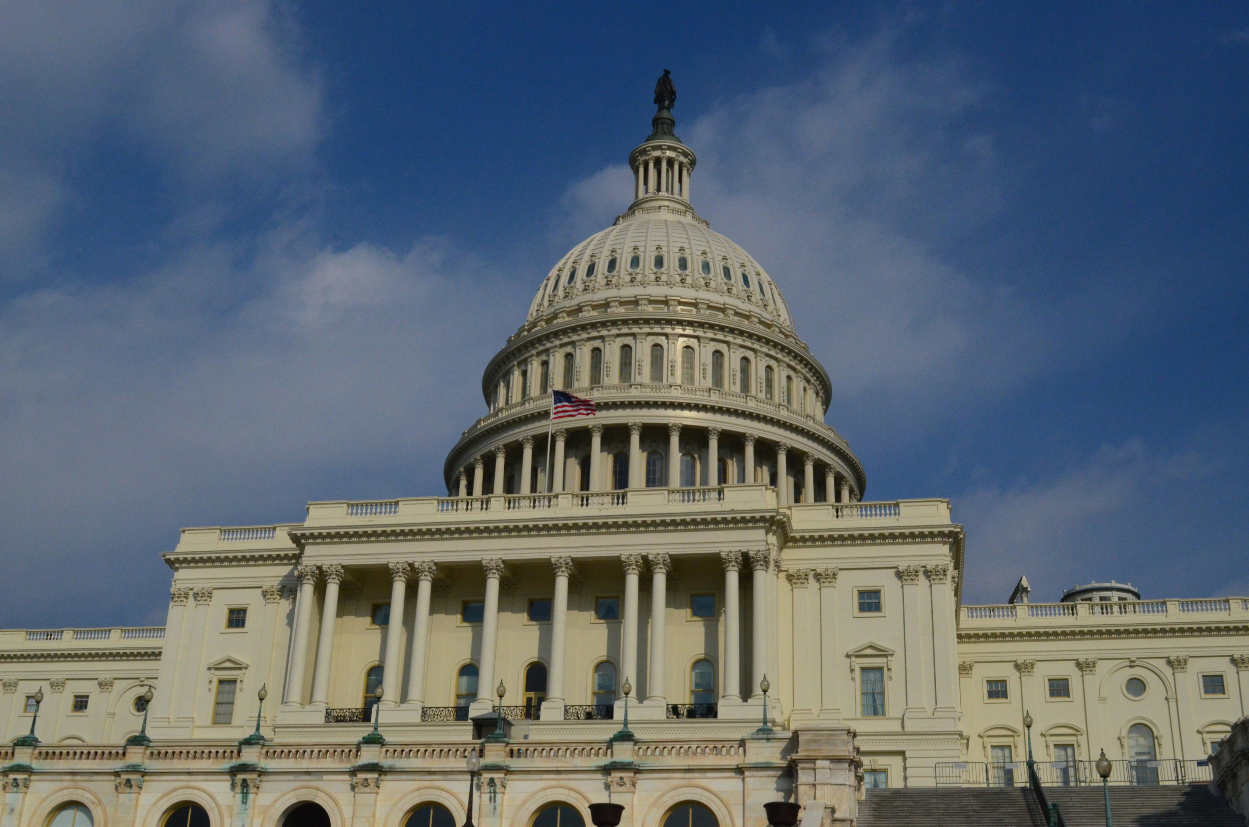 https://d.ibtimes.com/en/full/4631144/us-flag-flying-capitol-building-washington-dc.jpg