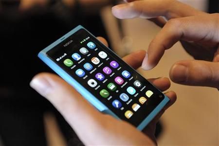 A staff member displays a Nokia N9 smartphone at a news conference in Espoo