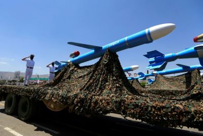 Houthi soldiers stand guard on a missile carrier