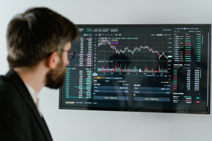 A businessman in a suit looks at a screen displaying