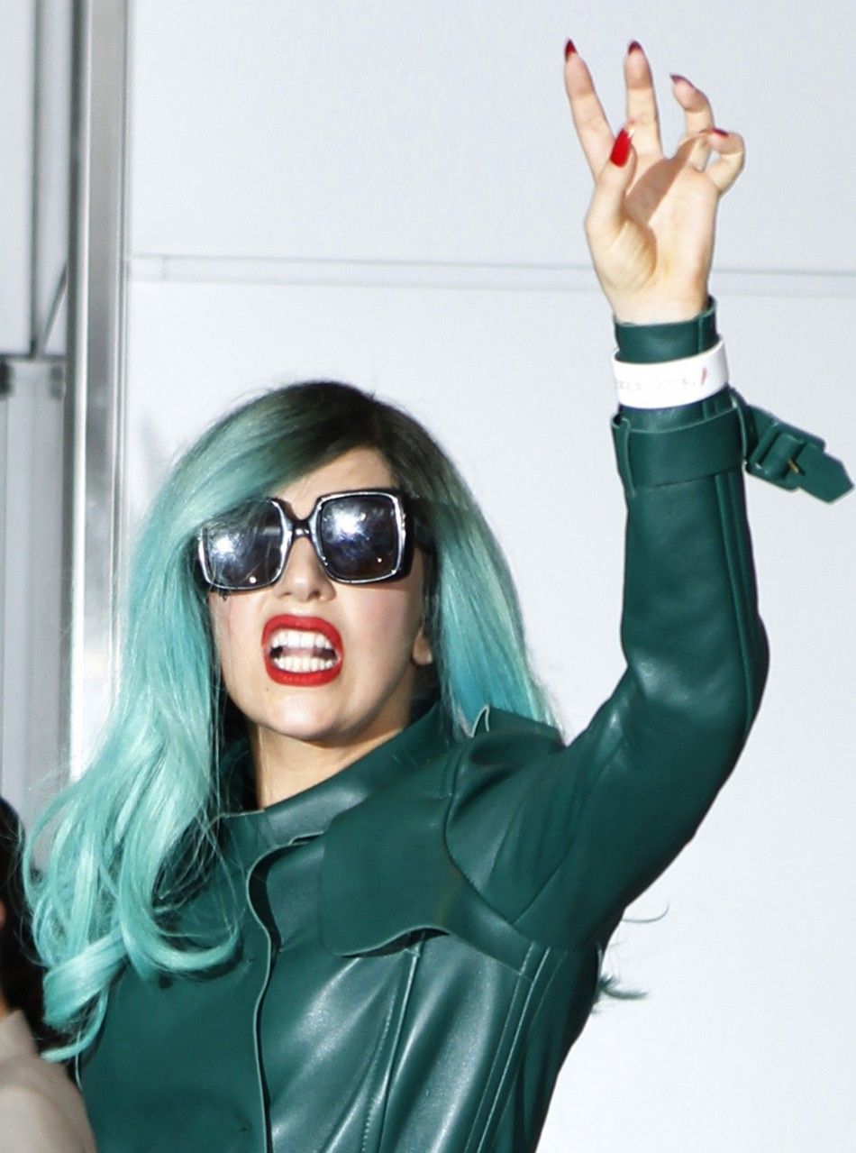 Lady Gaga gestures upon her arrival at Narita International Airport.