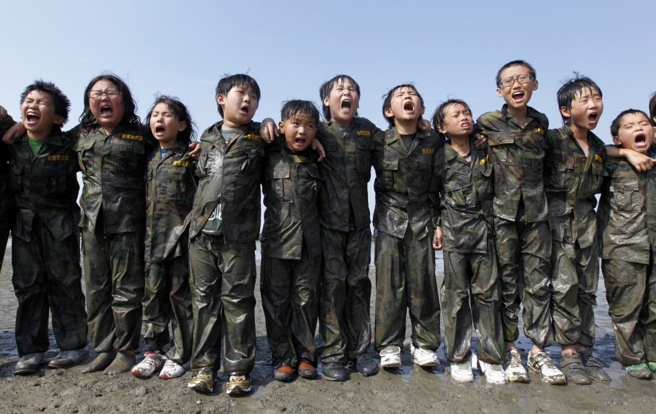 Elementary school students shout quotThanks to my parentsquot at a mud flat as they participate in a summer military camp for civilians at the Cheongryong Self-denial Training Camp run by retired marines in Ansan