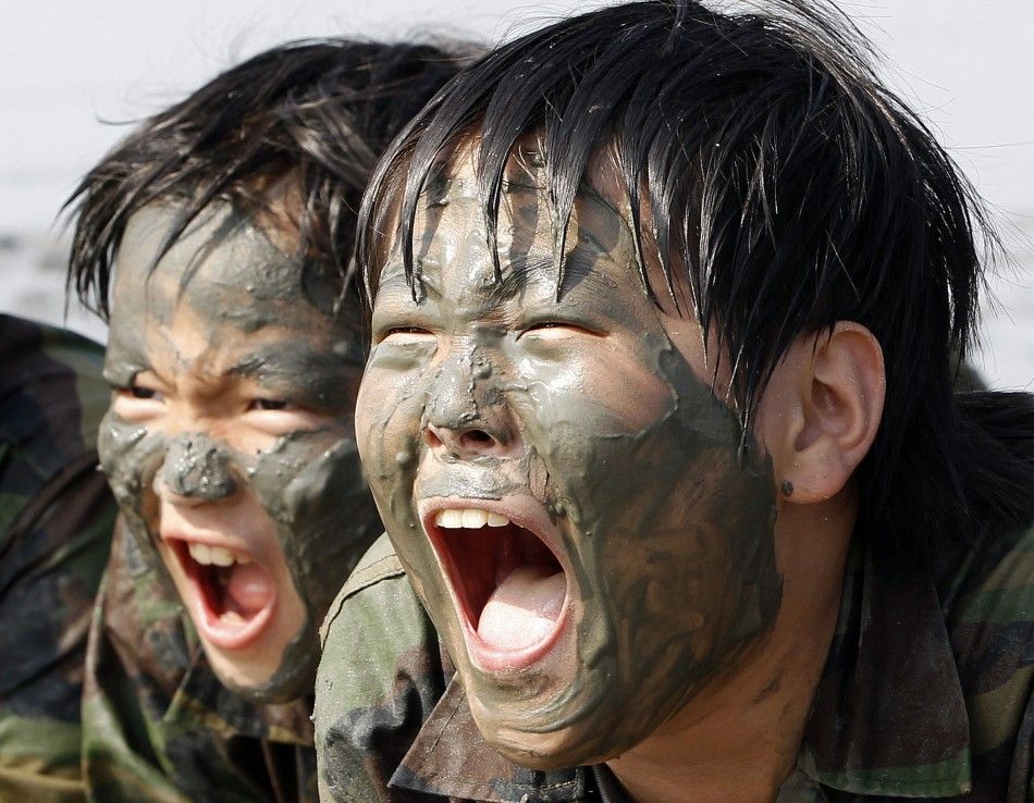 Elementary school students scream at a mud flat as they participate in a summer military camp for civilians at the Cheongryong Self-denial Training Camp run by retired marines in Ansan