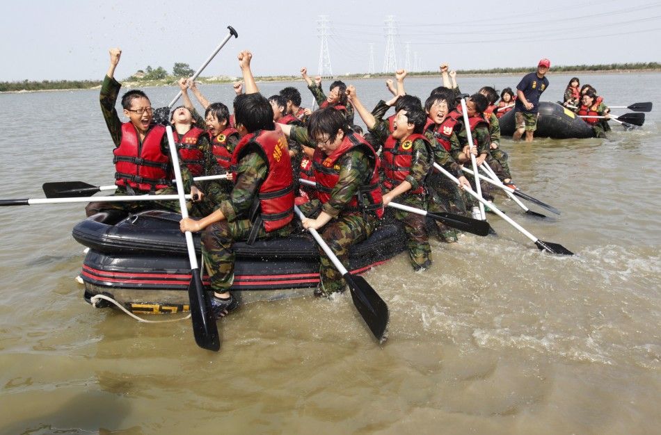 Elementary school students celebrate in a rubber boat as they participate in a summer military camp at the Cheongryong Self-denial Training Camp in Ansan