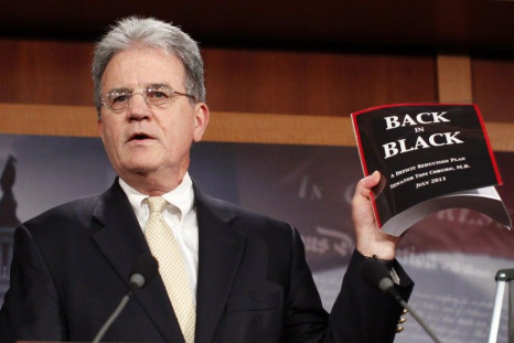 U.S. Senator Tom Coburn (R-OK) holds up a copy of his deficit-reduction plan during a media availability in the Capitol in Washington