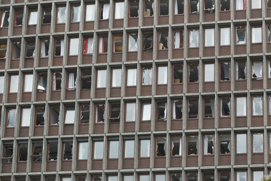 Broken windows of a government building are seen after a powerful explosion rocked central Oslo