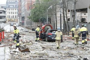 Rescue workers work at the site of a powerful explosion rocked central Oslo