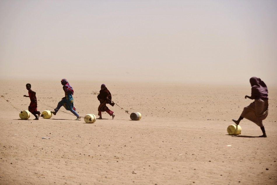 People roll and drag water containers in Wajir