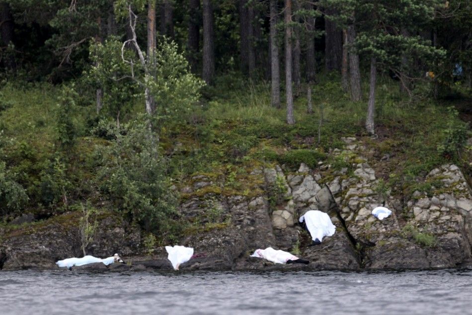 Covered corpses are seen on the shore of the small, wooded island of Utoeya