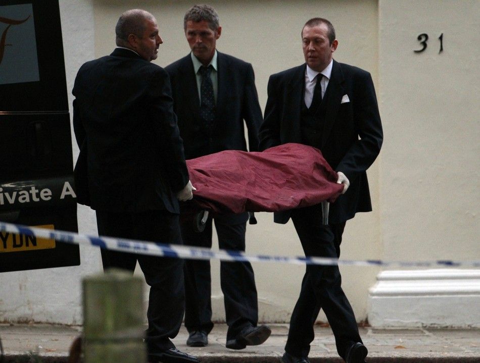 Funeral workers carry the body of Amy Winehouse outside her house in London