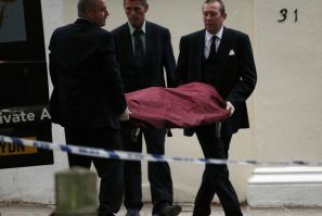 Funeral workers carry the body of Amy Winehouse outside her house in London