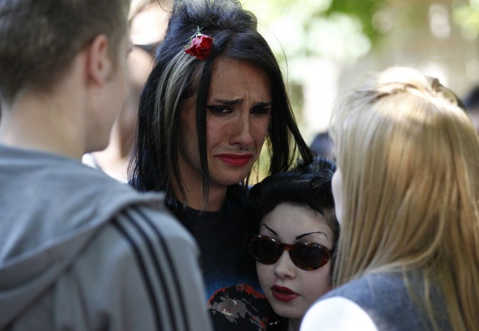 Fans react as they gather outside the home of Amy Winehouse in London