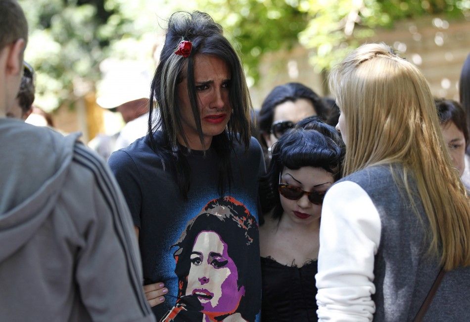 Fans react as they gather outside the home of Amy Winehouse in London