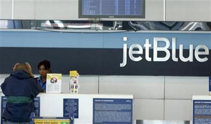A JetBlue employee assists a customer at the check-in counter at JFK International Airport in New York