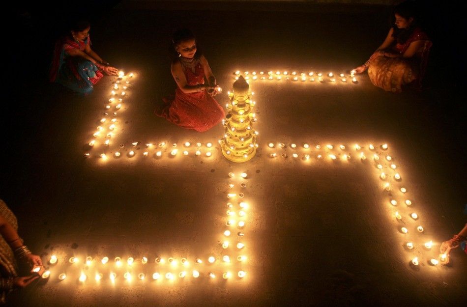 People light earthen lamps in a formation of the 039Swastika039, a Hindu symbol of peace, a day before the Hindu festival of Diwali, the festival of lights, in the western Indian city of Ahmedabad