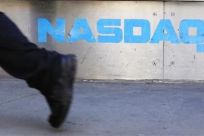 A pedestrian walks past the NASDAQ building in New York City