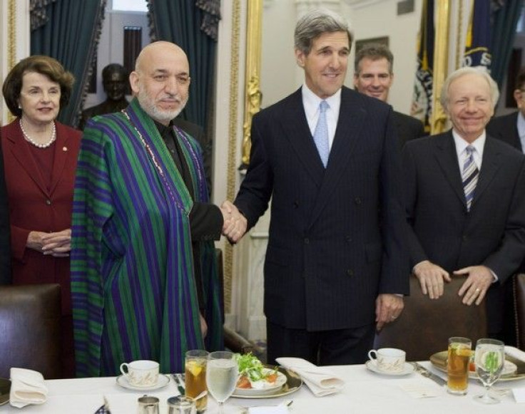 Afghan President Hamid Karzai (2nd L) shakes hands with Senator John Kerry (D-MA) during a luncheon hosted by the Senate Foreign Relations Committee