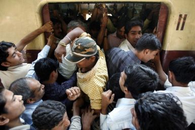 Commuters make their way into a crowded compartment of a local train in Mumbai