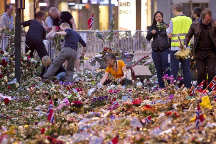 Workers remove flowers and candles placed in front of Oslo Cathedral, in memory of the victims of the July 22 attacks