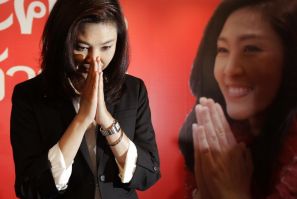 Yingluck Shinawatra greets reporters and supporters gathered at her party's headquarters after voting in general elections ended in Bangkok