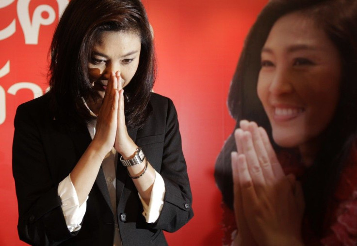 Yingluck Shinawatra greets reporters and supporters gathered at her party's headquarters after voting in general elections ended in Bangkok