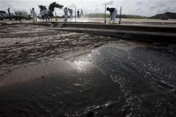 Workers pressure-wash oil from the Deepwater Horizon spill from a roadway in Waveland, Mississippi