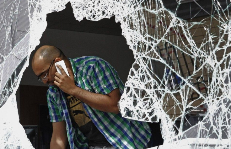 A man standing near broken window