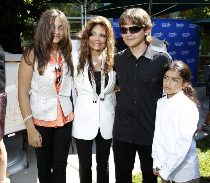 The children of late singer Michael Jackson, Prince Michael Joseph Jackson Jr. (2nd R), Paris-Michael Katherine Jackson (L) and Prince Michael Jackson II (Blanket) (R), pose with their aunt La Toya Jackson during a private ceremony at the Children's Hospi