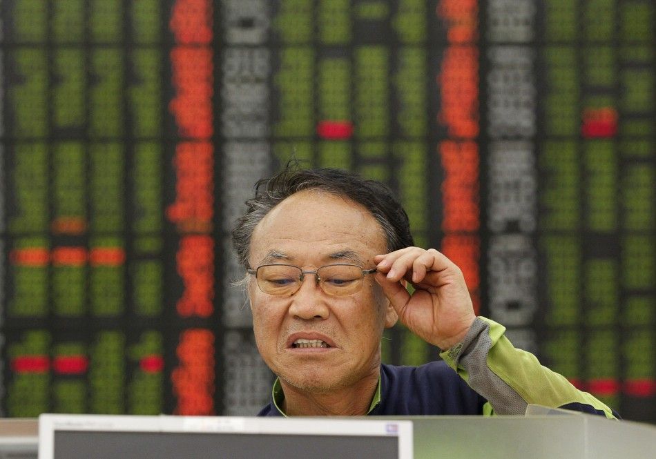 An investor reacts as he looks at a computer monitor showing stock prices in a customer lounge of a stock trading firm in Seoul