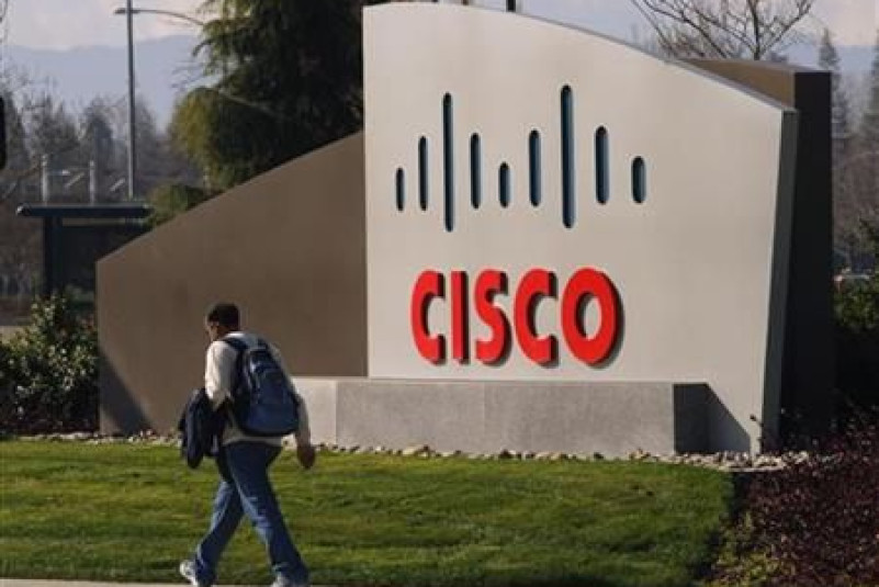 A pedestrian walks past the Cisco logo at the technology company's campus in San Jose