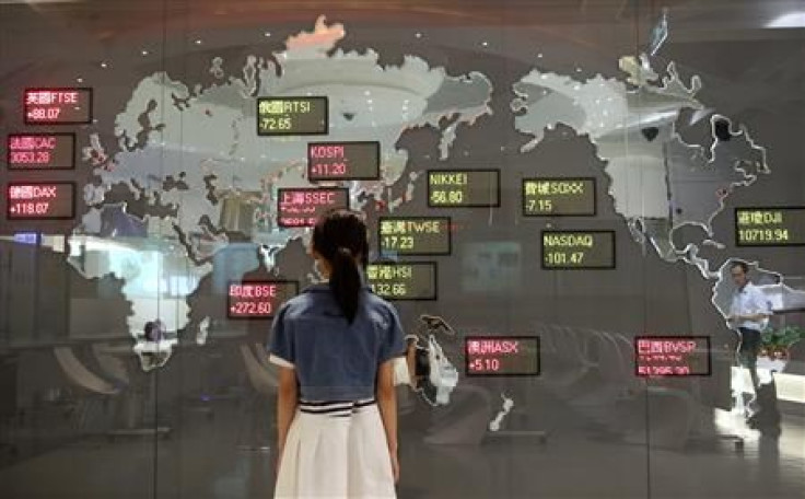 A girl looks at a board showing global stock indices at the Taiwan Stock Exchange in Taipei