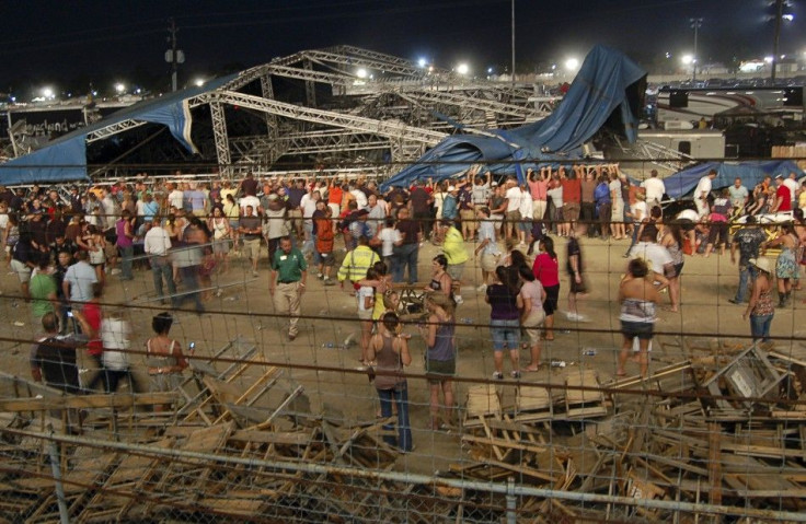 Concertgoers and emergency personnel hold up stage rigging after it collapsed at the Indiana State Fairgrounds in Indianapolis