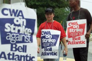 Communication Workers of America union members Lynn Oldenburg (L) and Geoffrey Lawson (R) walk the picket line at a Verizon office complex in Silver Spring, Maryland, August 7, 2000