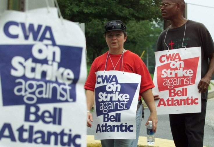Communication Workers of America union members Lynn Oldenburg (L) and Geoffrey Lawson (R) walk the picket line at a Verizon office complex in Silver Spring, Maryland, August 7, 2000