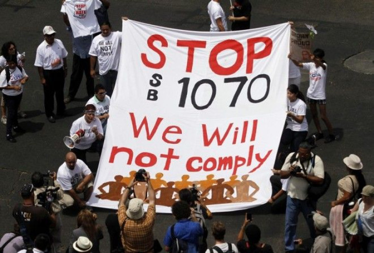 Demonstrators hold a banner as they protest against Arizona's controversial Senate Bill 1070 immigration law outside the U.S. District Court in Phoenix July 22, 2010. 