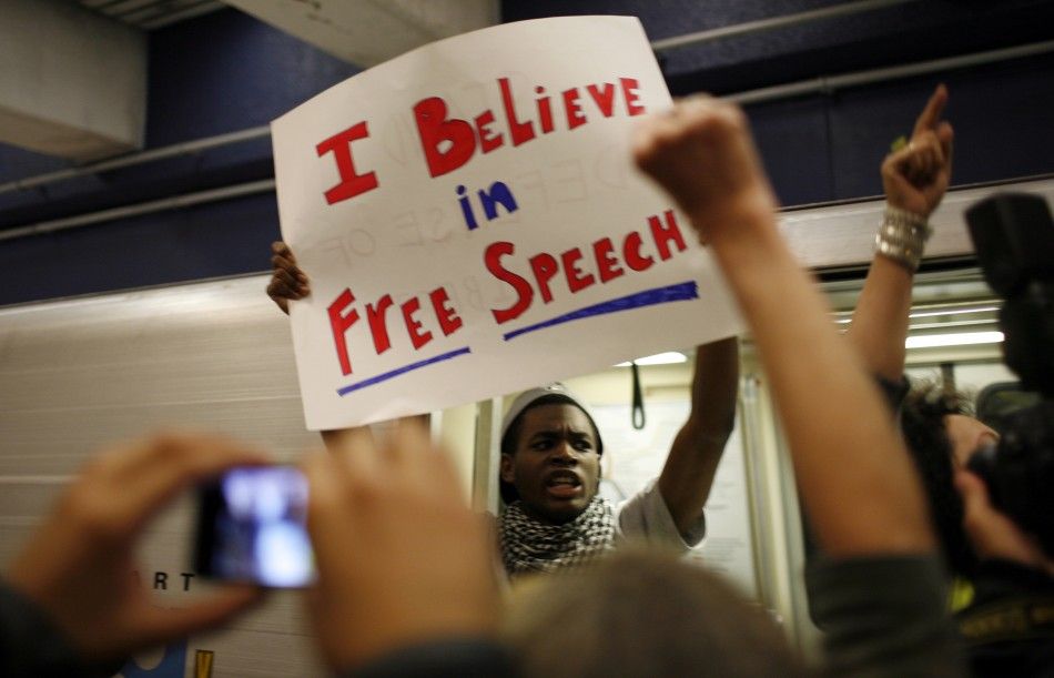 A protester holds up a sign on a BART train during a demonstration at the Civic Center Station in San Francisco